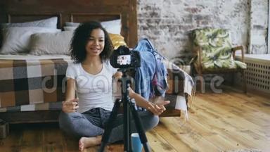 微笑卷曲的非洲裔美国女孩<strong>录制</strong>视频博客她的衣柜旅行与dslr相机在家
